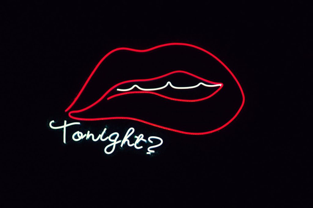 Creative neon sign featuring lips and 'Tonight?' on a black background.
